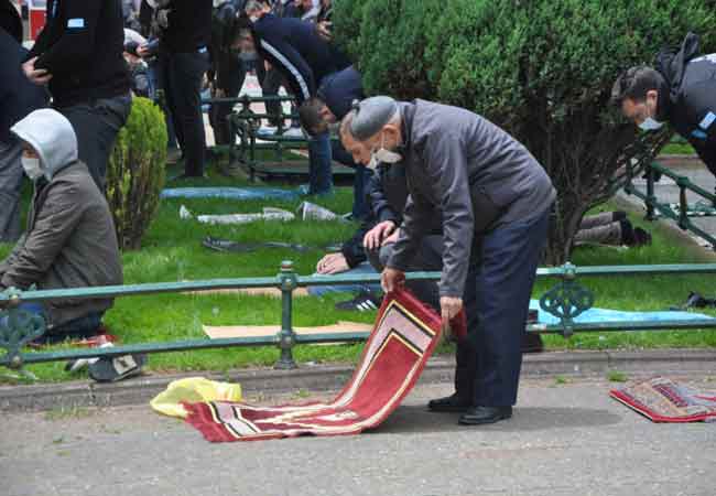 Bahçelerde ise çimlerin üzerinde yer alan beyaz şeritler üzerinde namaz kılındı. 