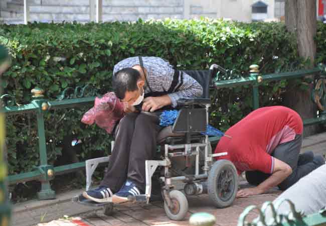 Namaz vaktinde başlayan yağmurdan şemsiye ve kartonlarla korunan vatandaşlara, sık sık kurallara uymaları noktasında anonslar yapıldı. 