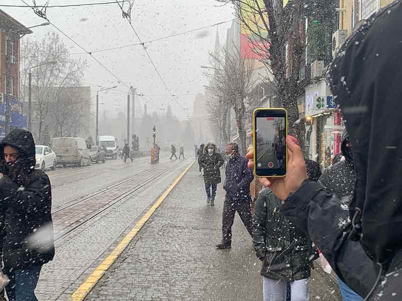 Eskişehir’de öğleden sonra rüzgârla birlikte aniden bastıran yoğun kar yağışı, vatandaşlar arasında şaşkınlıkla karşılanırken, kent merkezinde ilginç görüntüler oluştu.