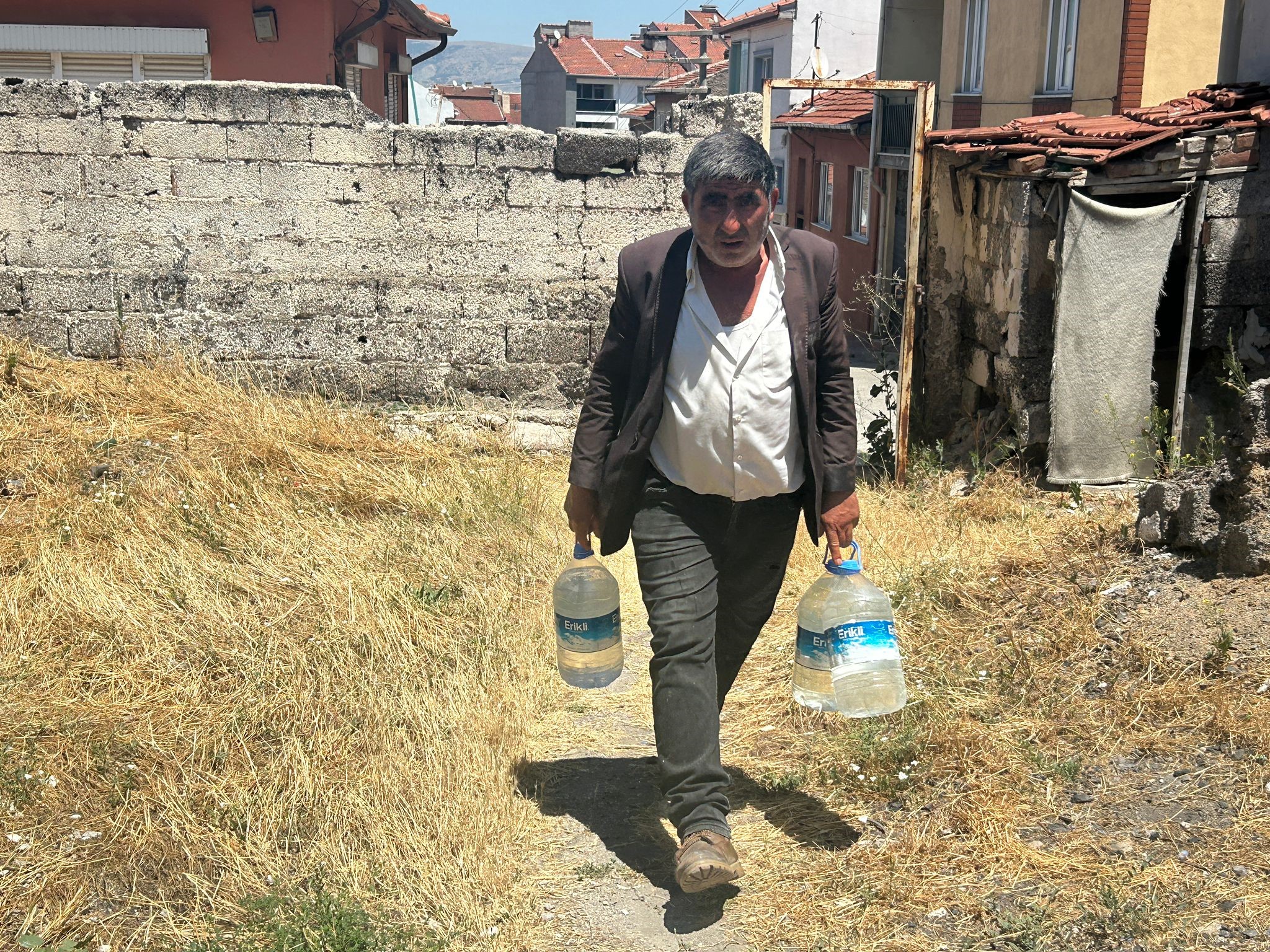 Eskişehir'de yıkılmaya yüz tutmuş bir gecekonduda tek başına yaşayan 54 yaşındaki Kadir Karpuz, su ihtiyacını cami şadırvanından doldurup evine taşıdığı bidonlarla karşılıyor, güğümde su ısıtıp yıkanıyor.