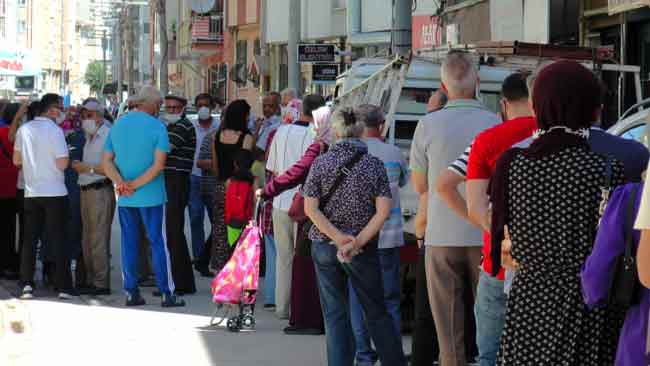 Sıcakta güneşin altında bekleyemeyen bazı vatandaşlar kaldırımlarda oturdu.