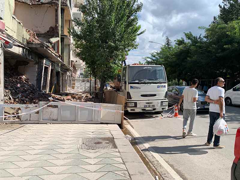 Eskişehir'de cadde üzerinde bulunan bir binanın yıkım çalışmasından dolayı kapatılan kaldırım, vatandaşların araçların arasından yürümesine neden oluyor.