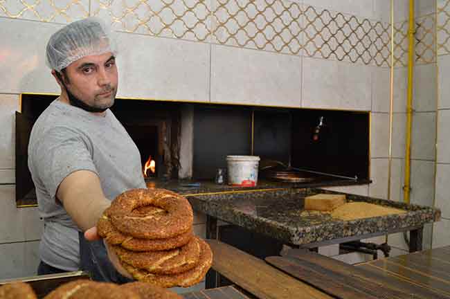 Eskişehir’de simit üretmek ve satmakta meşgul olan Selçuk Nadir, son zamanlarda diğer ürünlere gelen zamlar nedeniyle şuan yaptığı satışlardan bir kazanım elde edemediği, adeta bedavaya kürek çektiği belirtti. Simit fırıncısı Nadir, konu ile ilgili konuşurken, “Şu anda unun fiyatları 130 -140 lira oldu. Doların artışından dolayı dışarıdan geldiği için bizim susamların fiyatlarında da oynama oldu. Her şey gelen zamdan dolayı simidin fiyatını da güncellenmesi gerekiyor, geç kalınan bir şey hatta. Şu anda zararda da değil kârda da değil. Yani bedavaya kürek çekiyoruz şu anda. Yapılacak zamlar şu anlık yetecek. Aslında yetmeyecek, ama şu anlık yeterli. Başka şehirleri baz alırsanız Bursa’da, Ankara’da simitler 2 liraya satıyorlar. Susamın maliyeti çok yüksek oldu. Simit ekmek gibi değil yani. Simidin hamuru ile ekmeğin hamuru bir değil. Ekmek hamuruna giren suyla simit hamuruna giren su aynı değil. İşçilik maliyetleri çok daha yüksektir. İnsanlar ekmek ve simidi kıyaslıyorlar. Ama simit özel tüketim olduğu için ekmekle kıyaslanacak bir ürün değil” diye anlattı.