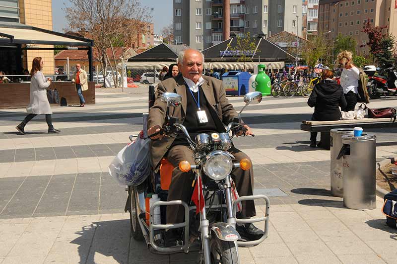 Eskişehir’de yaşayan 83 yaşındaki Ahmet Er, ilkokulda kum üzerine çizerek başladığı resim sanatını 70 yıldır sürdürüyor ve eserlerini motosikleti ile köy köy dolaşarak sergiliyor. 