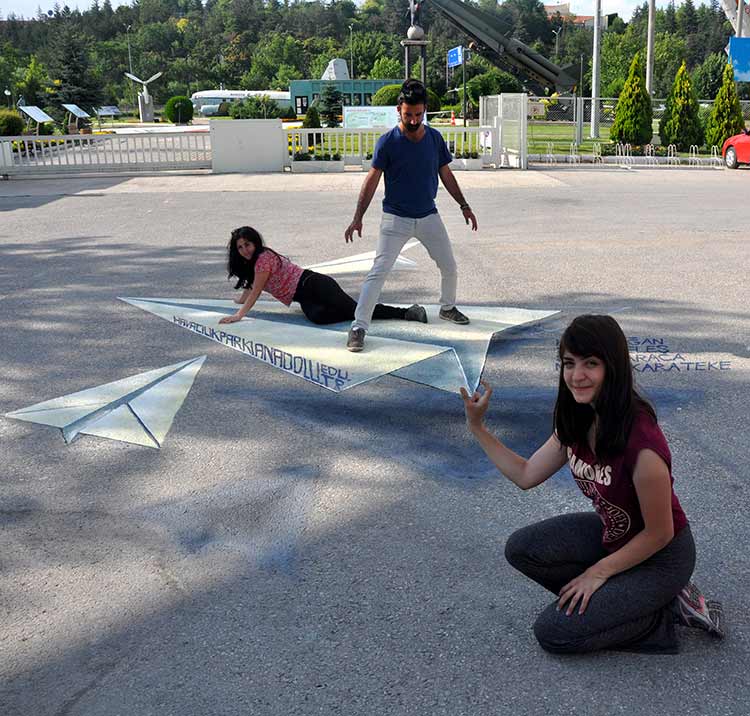 Eskişehir'de, Anadolu Üniversitesi (AÜ) Güzel Sanatlar Fakültesi öğrencileri Sefa Karaca, Selin Keleş ile Merve Karateke dünyaca ünlü sokak resmi sanatçısı Alex Maksiov'u örnek alarak AÜ Havacılık Parkı'na "kağıt" uçakların 3 boyutlu resimlerini çizdi.