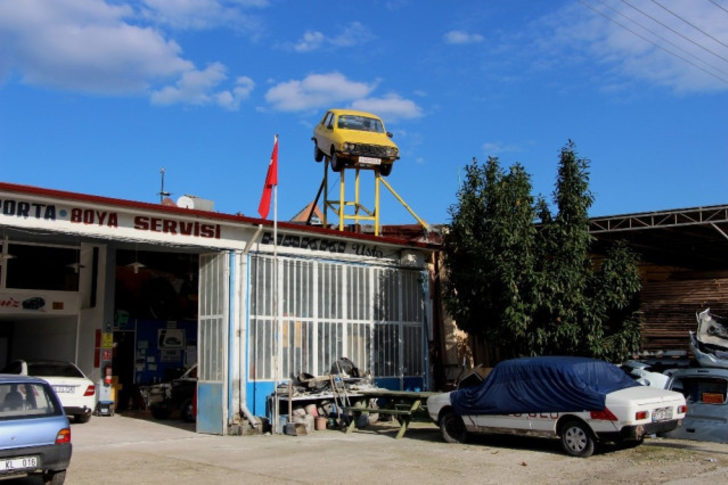 Karadenizli kaportacı yaptı, gören dönüp bir daha bakıyor. Bir kaporta ustasının iş yerinin çatısına koyduğu otomobil, uzaktan bakınca ''uçan araba'' sanılıyor.